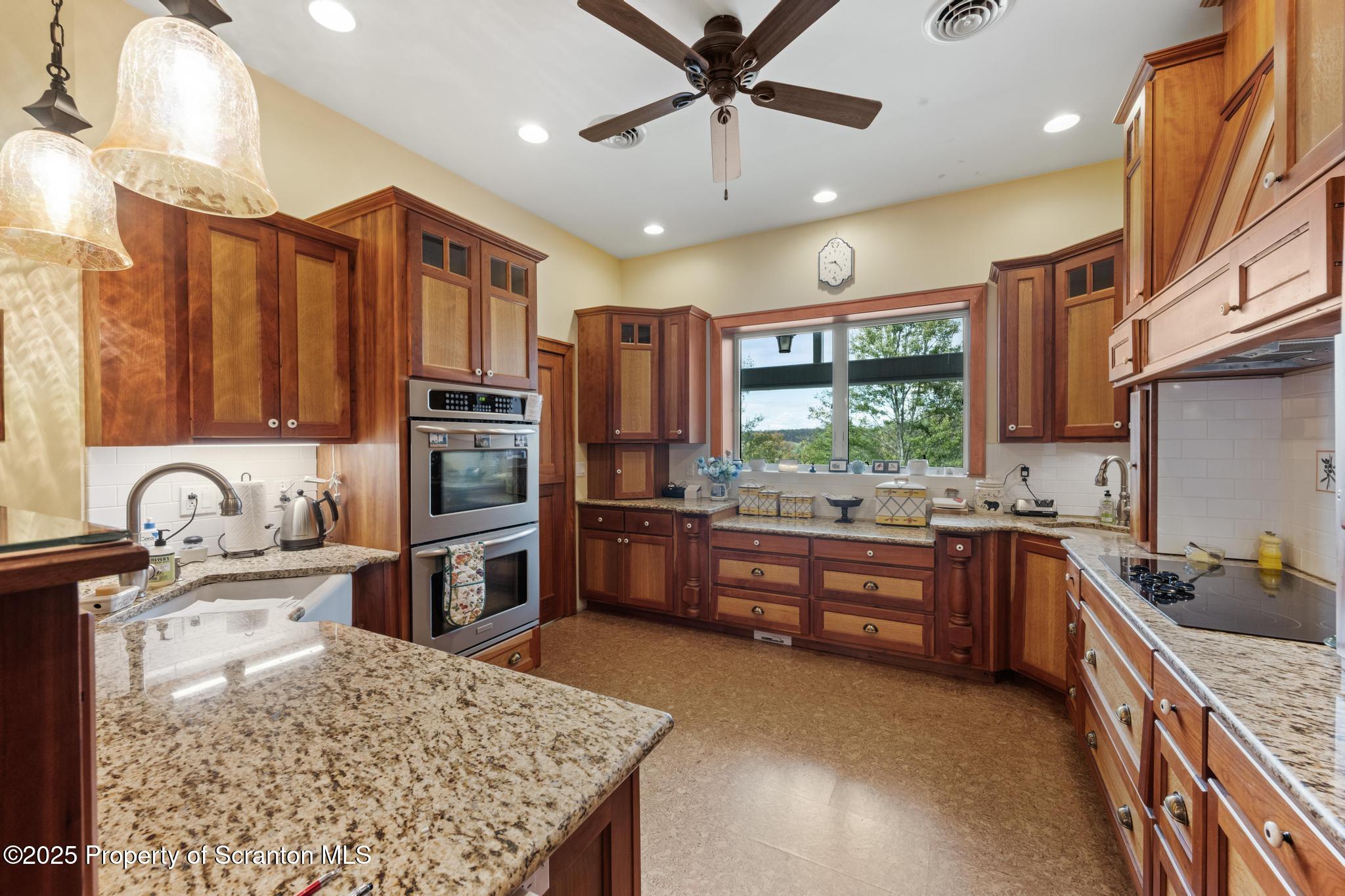 118 Autumn View Lane Factoryville, PA 18419 - Photo 18 of 28 a kitchen with large cabinets a stove a sink a dining table and chairs