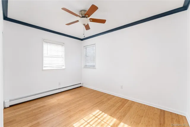 an empty room with a window and ceiling fan
