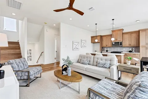 a living room with furniture kitchen and a chandelier