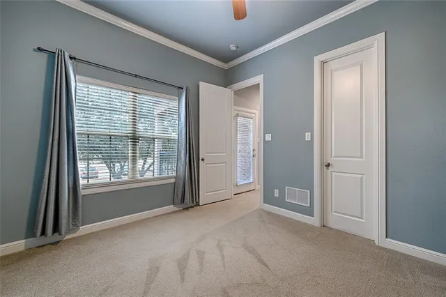 a view of an empty room with a window and a bathroom