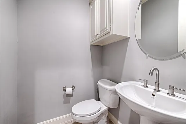 a bathroom with a sink a toilet and mirror
