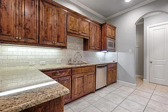 a kitchen with stainless steel appliances granite countertop wooden cabinets a sink and dishwasher