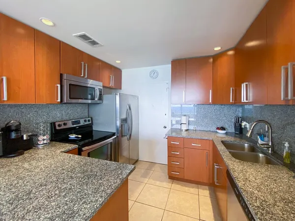 a kitchen with stainless steel appliances granite countertop a sink stove and refrigerator