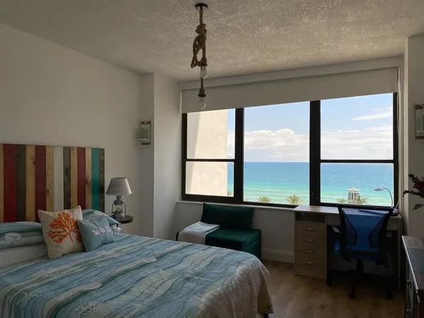 a bedroom with a large window and a bed