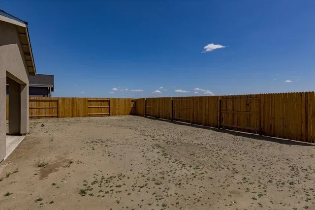 a view of backyard with wooden fence
