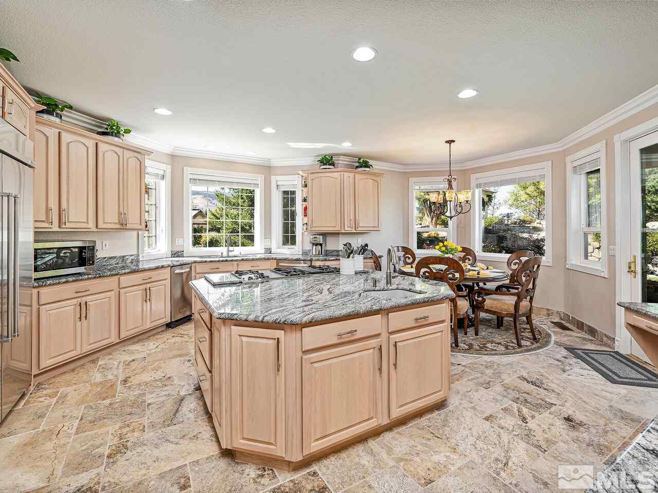 13215 West Saddlebow Drive Reno, NV 89511 - Photo 12 of 32 a kitchen with kitchen island granite countertop wooden cabinets a counter top space and stainless steel appliances
