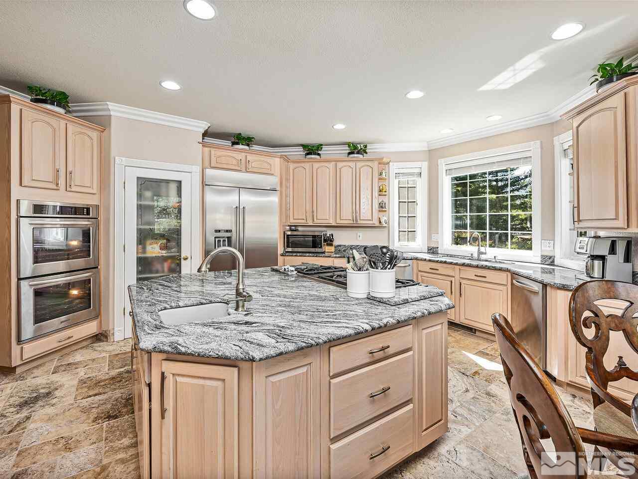 13215 West Saddlebow Drive Reno, NV 89511 - Photo 14 of 32 a kitchen with stainless steel appliances granite countertop a sink stove and cabinets