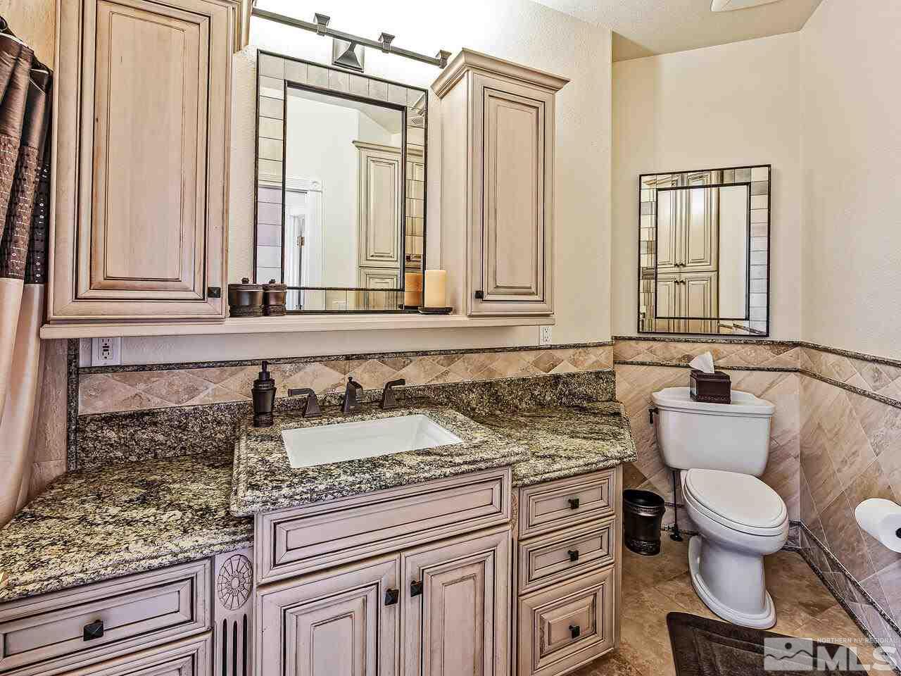 13215 West Saddlebow Drive Reno, NV 89511 - Photo 23 of 32 a bathroom with a granite countertop toilet sink and mirror