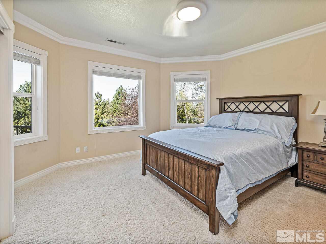 13215 West Saddlebow Drive Reno, NV 89511 - Photo 24 of 32 a bed sitting in a bedroom next to a window