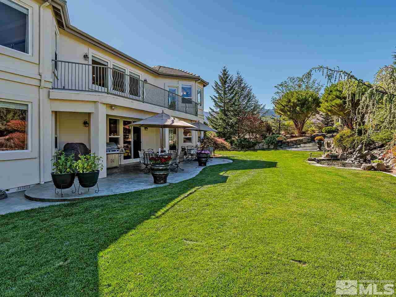 13215 West Saddlebow Drive Reno, NV 89511 - Photo 3 of 32 a view of a patio with table and chairs potted plants and large tree
