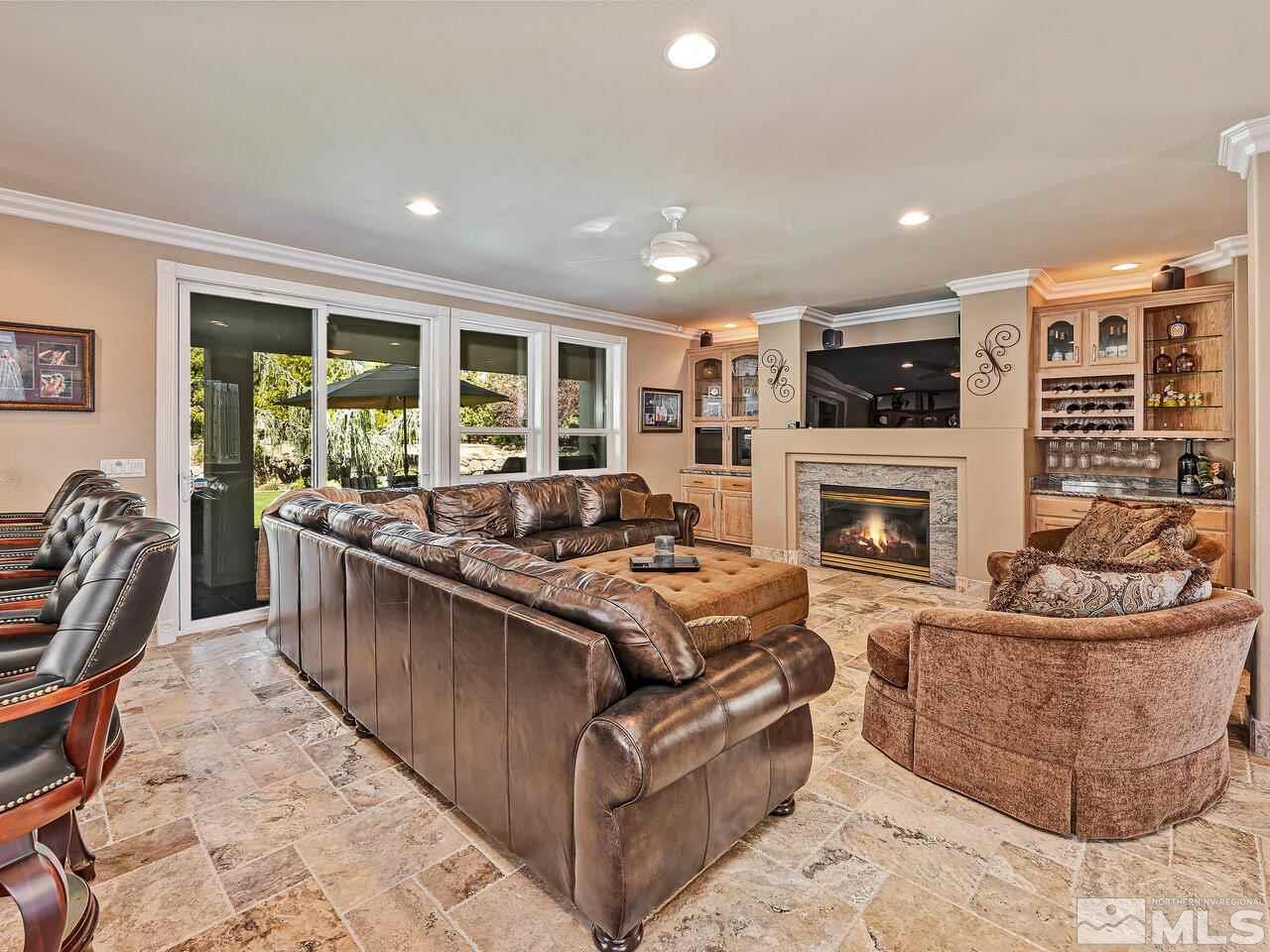 13215 West Saddlebow Drive Reno, NV 89511 - Photo 10 of 32 a living room with furniture a flat screen tv and a fireplace