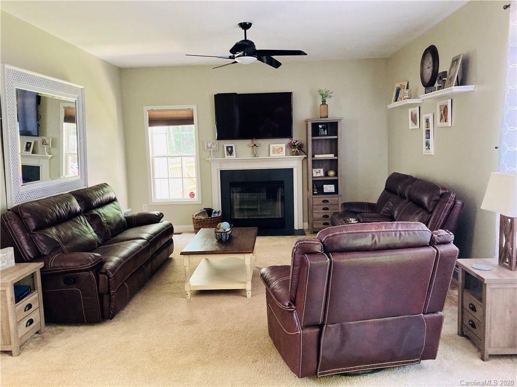 1173 Timber Spring Lane Salisbury, NC 28147 - Photo 14 of 38 a living room with furniture a flat screen tv and a fireplace
