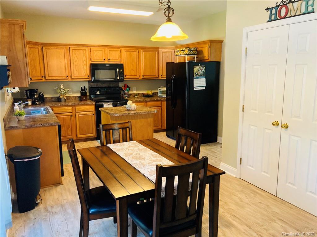 1173 Timber Spring Lane Salisbury, NC 28147 - Photo 15 of 38 a kitchen with a table chairs refrigerator and microwave