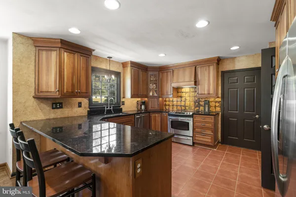 a kitchen with stainless steel appliances granite countertop a stove refrigerator sink and cabinets