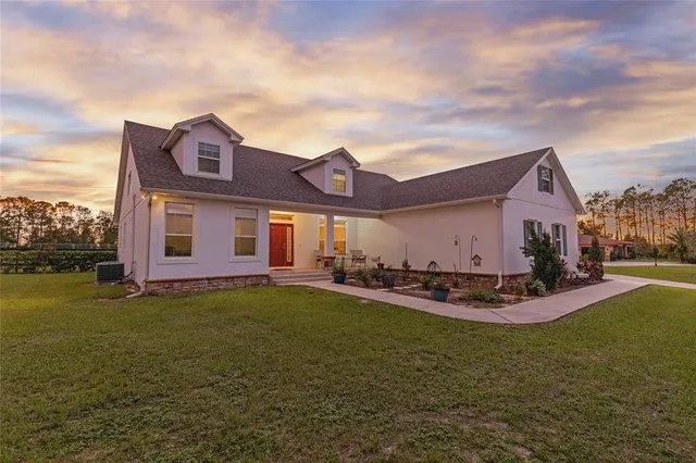a view of a house with a big yard and a large tree