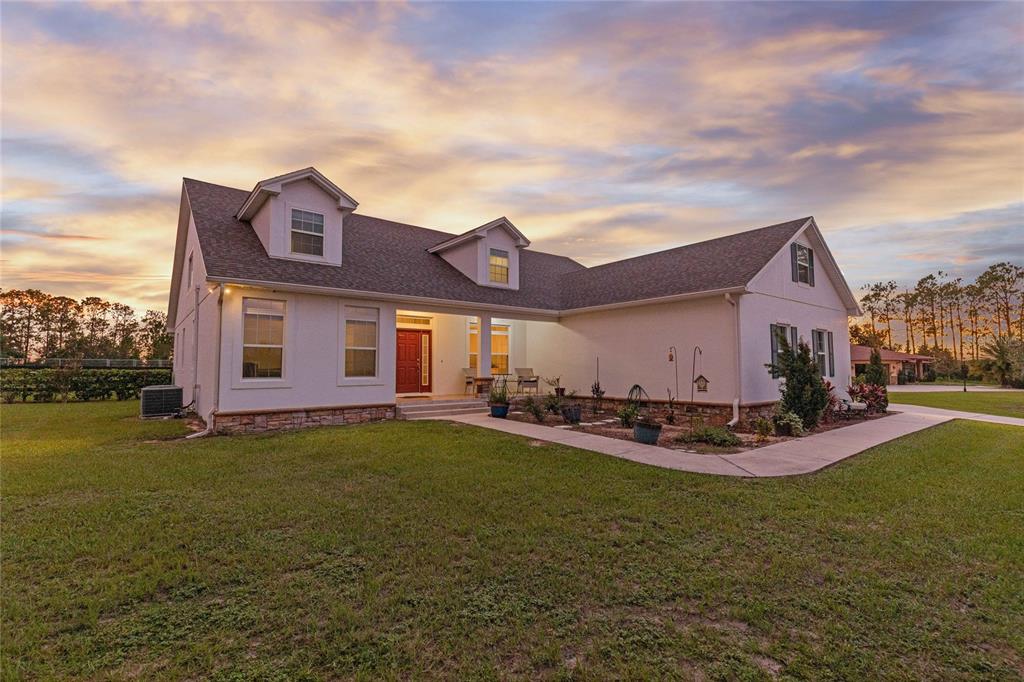 a view of a house with a big yard and a large tree