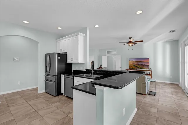 a bathroom with a granite countertop sink a mirror and shower