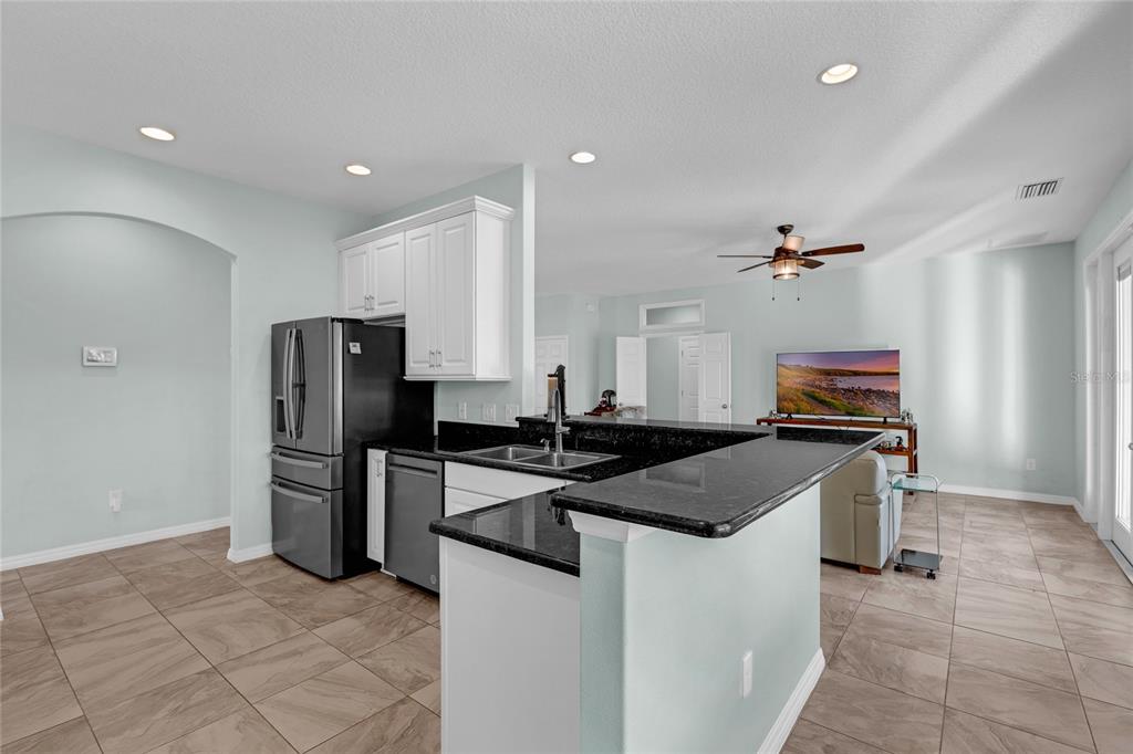 5608 Strong Point Weirsdale, FL 32195 - Photo 13 of 71 a kitchen with stainless steel appliances granite countertop a stove refrigerator and microwave