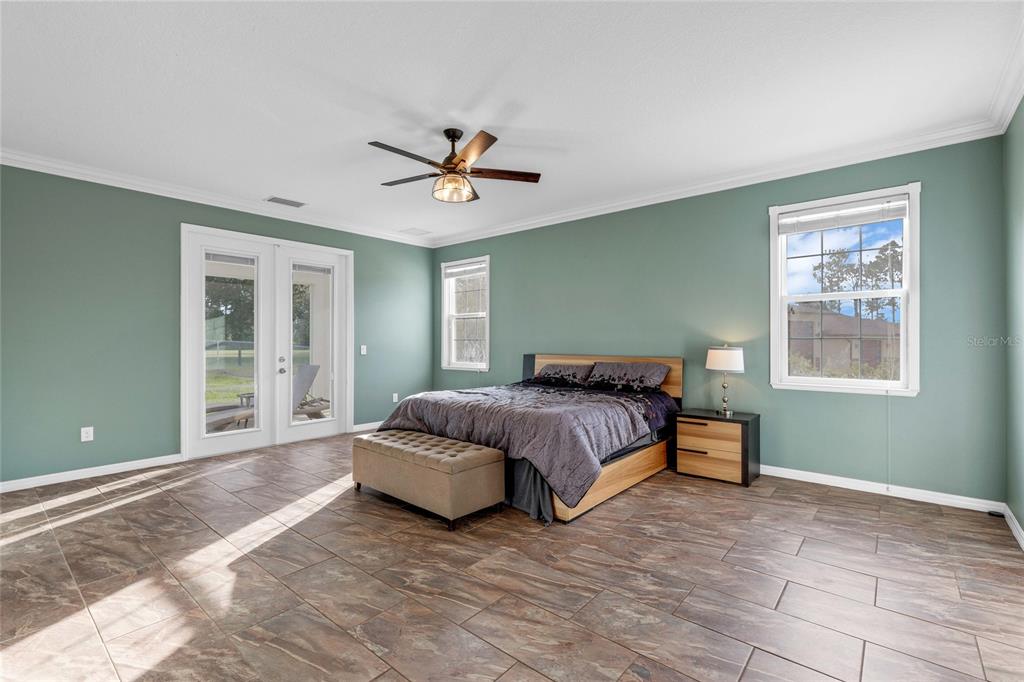 5608 Strong Point Weirsdale, FL 32195 - Photo 15 of 71 a spacious bedroom with a large bed and a window