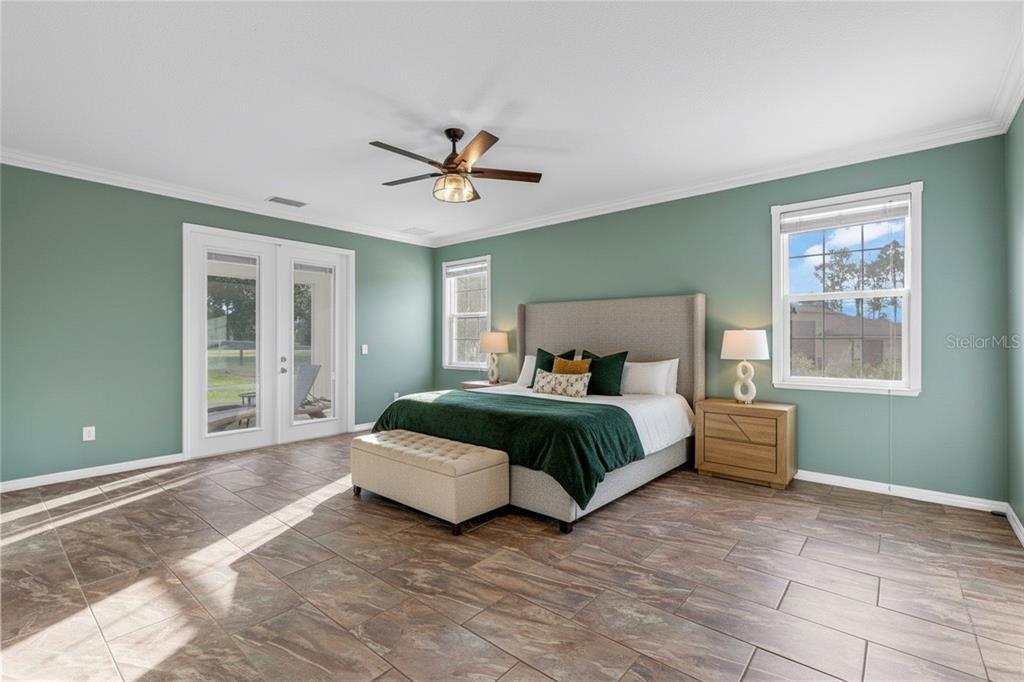 5608 Strong Point Weirsdale, FL 32195 - Photo 17 of 71 a spacious bedroom with a large bed and a window