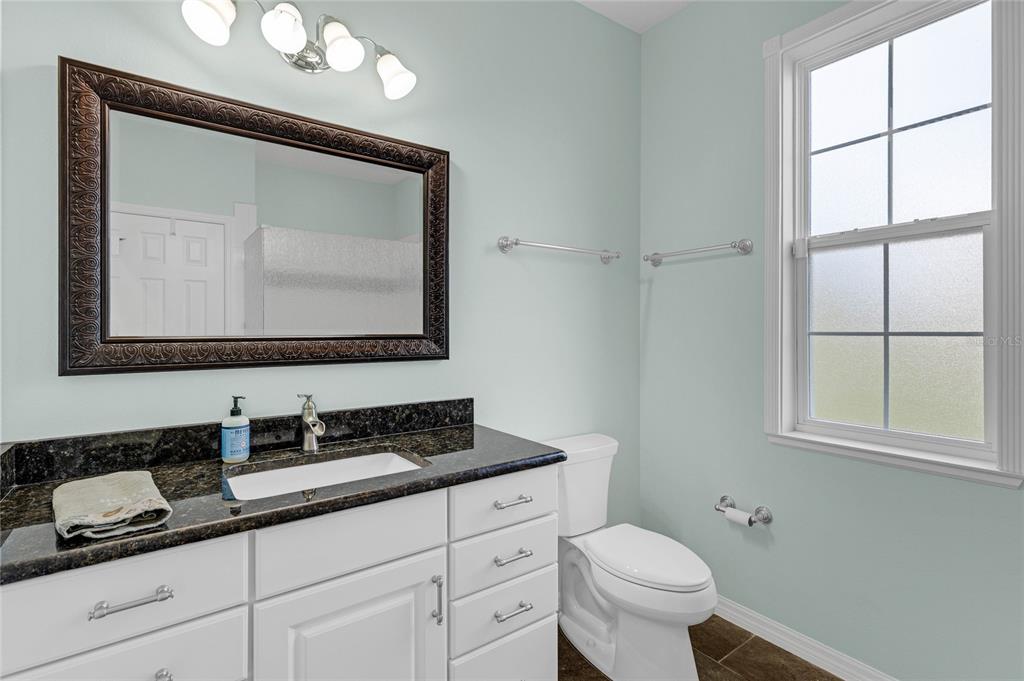 5608 Strong Point Weirsdale, FL 32195 - Photo 25 of 71 a bathroom with a toilet sink and mirror