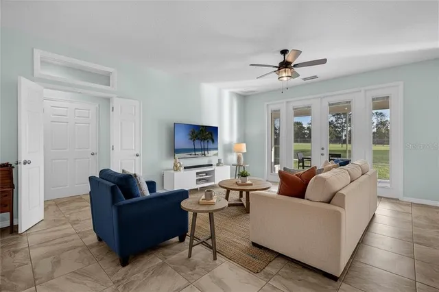 a living room with furniture kitchen view and a chandelier