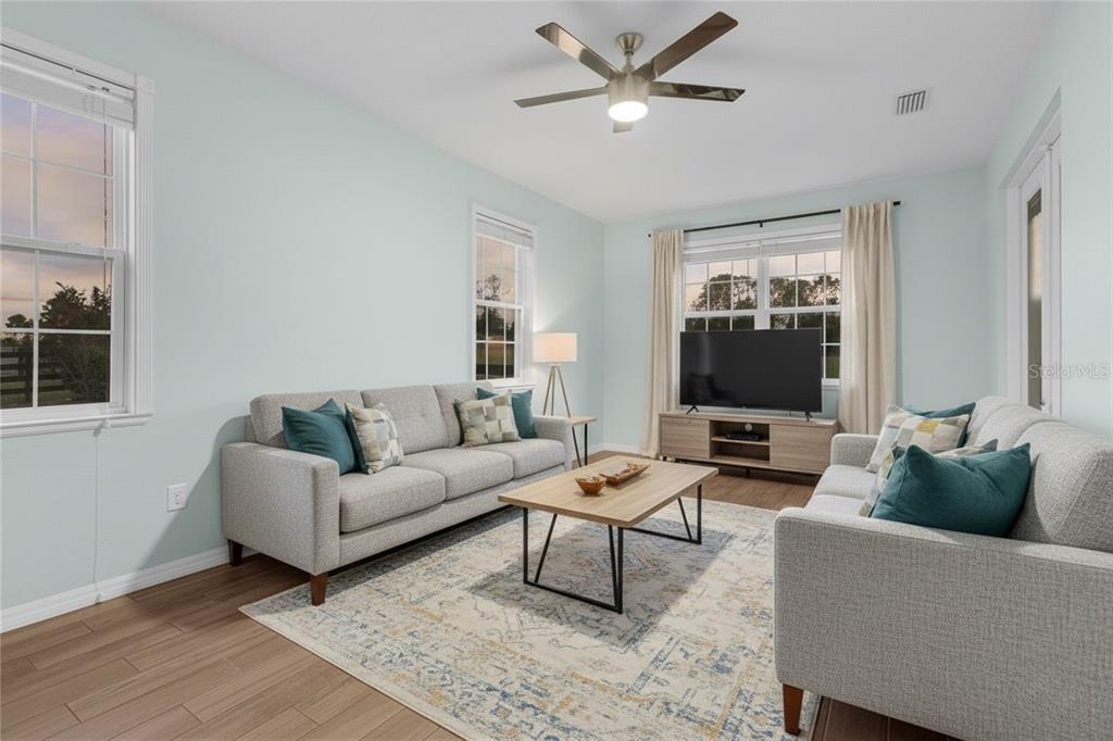 5608 Strong Point Weirsdale, FL 32195 - Photo 32 of 71 a living room with furniture a ceiling fan and a window