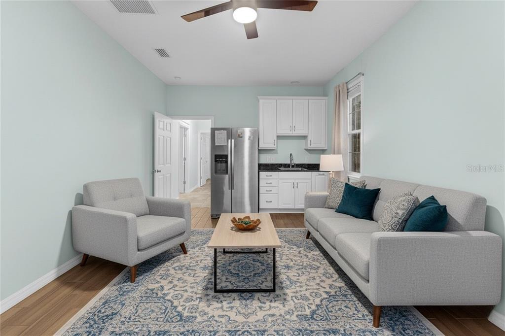 5608 Strong Point Weirsdale, FL 32195 - Photo 33 of 71 a living room with furniture and a chandelier