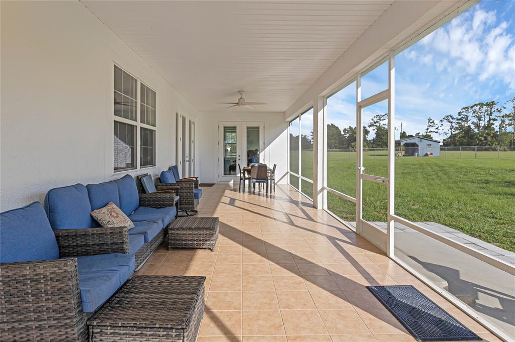 5608 Strong Point Weirsdale, FL 32195 - Photo 36 of 71 a living room with furniture floor to ceiling window and garden