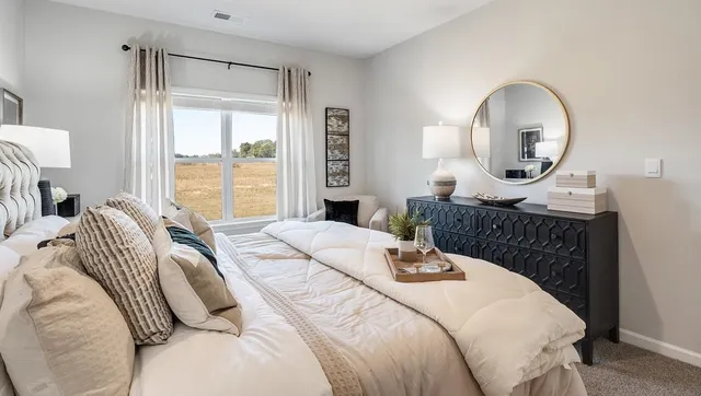 a bedroom with a bed and a large window