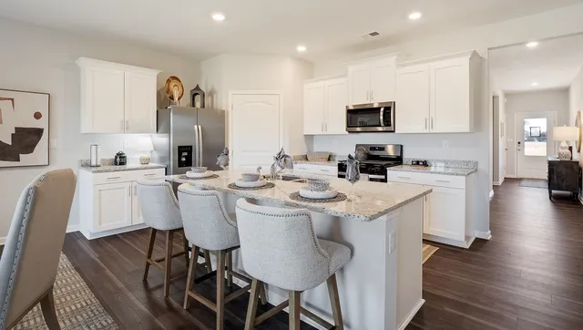a kitchen with stainless steel appliances kitchen island granite countertop a sink and cabinets