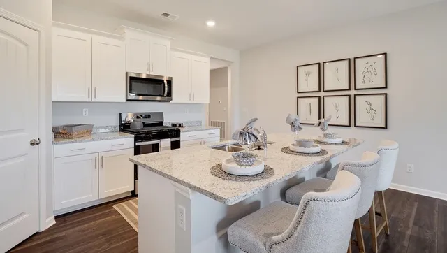 a kitchen with white cabinets stove and kitchen island
