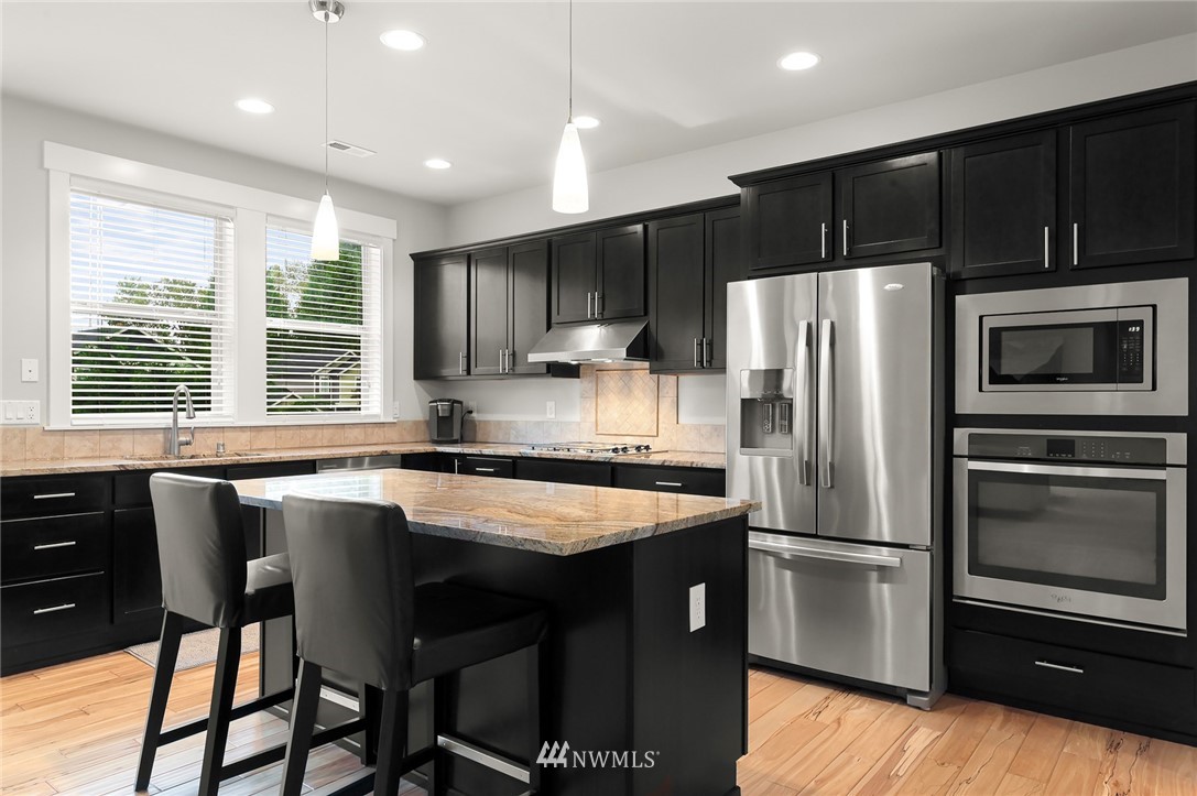 1017 Chelan Place Northeast Renton, WA 98059 - Photo 14 of 40 a kitchen with a refrigerator a microwave a sink and cabinets