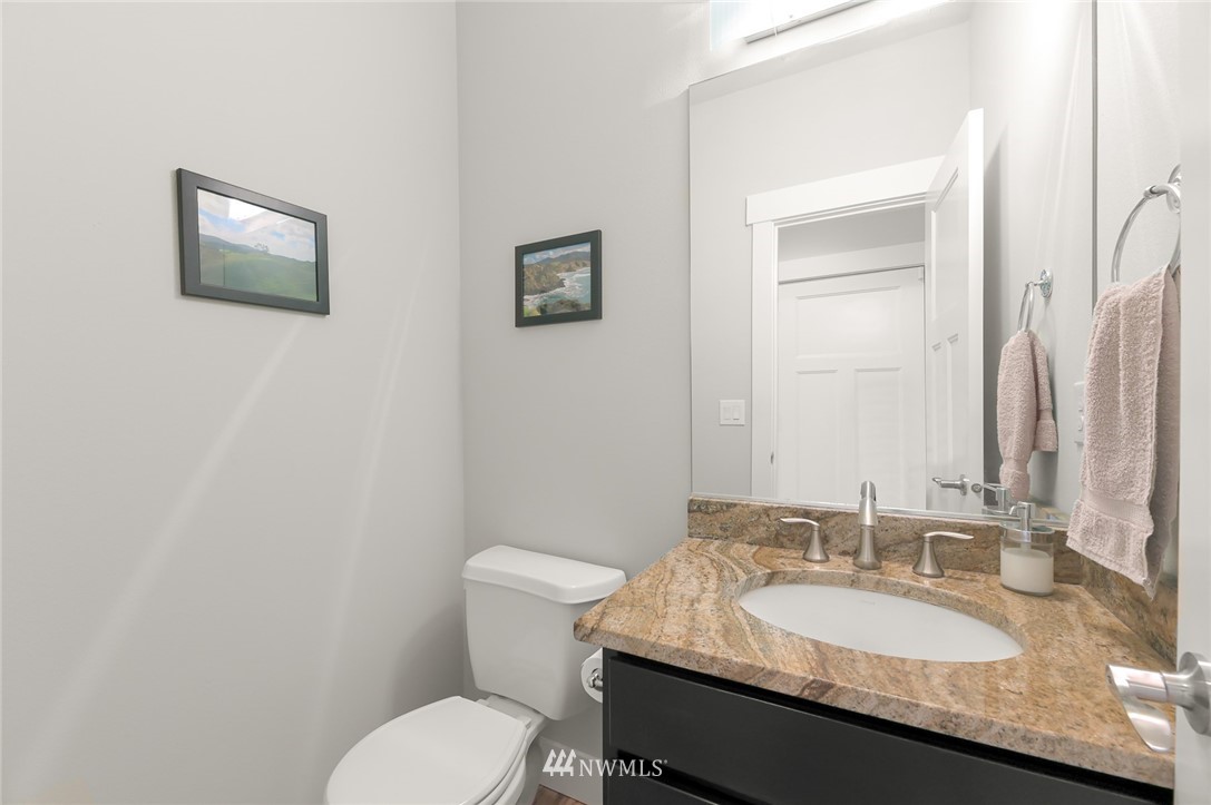 1017 Chelan Place Northeast Renton, WA 98059 - Photo 26 of 40 a bathroom with a granite countertop sink a toilet and mirror
