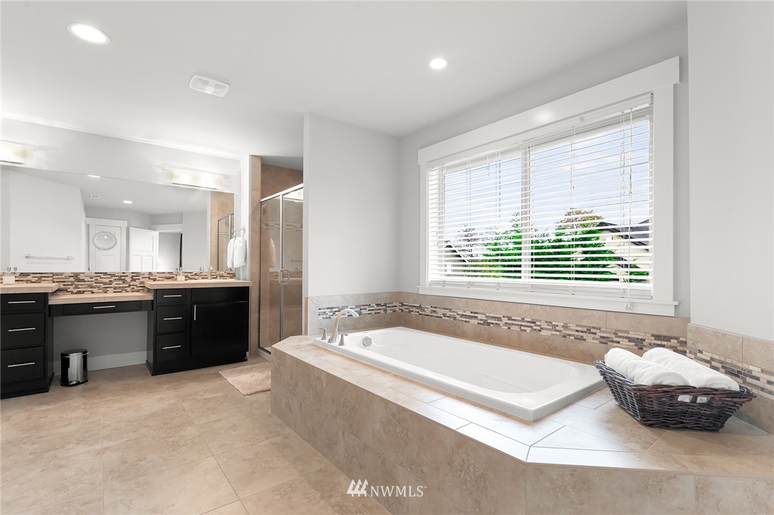 1017 Chelan Place Northeast Renton, WA 98059 - Photo 29 of 40 a spacious bathroom with a tub a sink and a large mirror