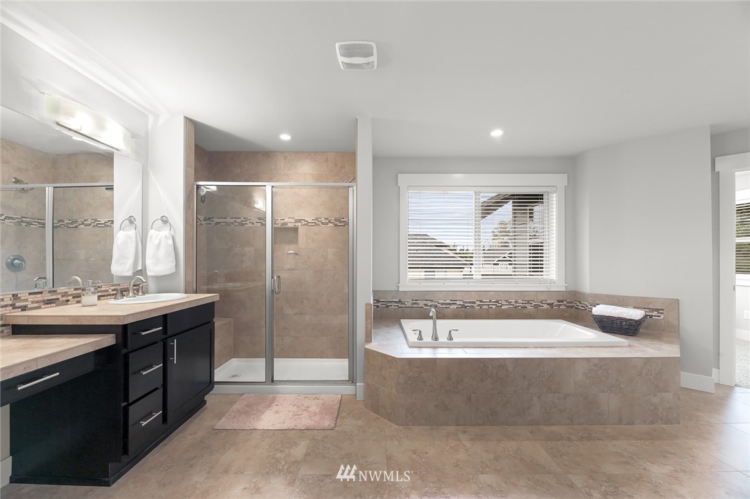 1017 Chelan Place Northeast Renton, WA 98059 - Photo 31 of 40 a spacious bathroom with a tub sink shower and mirror