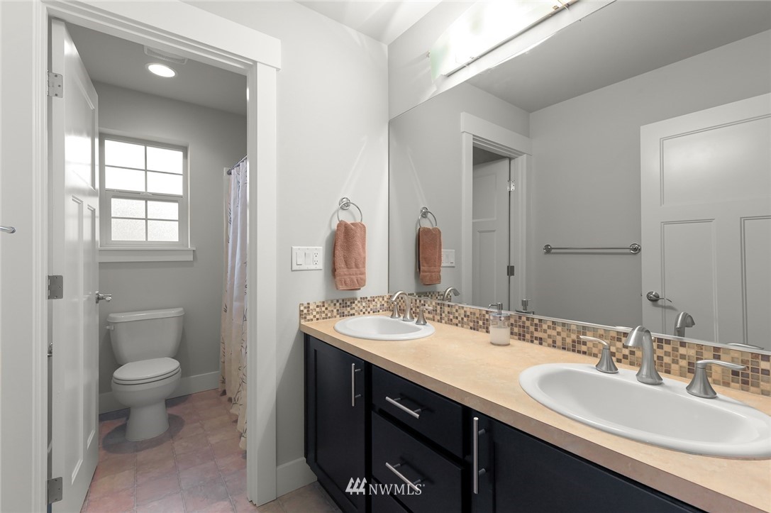 1017 Chelan Place Northeast Renton, WA 98059 - Photo 34 of 40 a bathroom with a granite countertop sink a toilet and a mirror