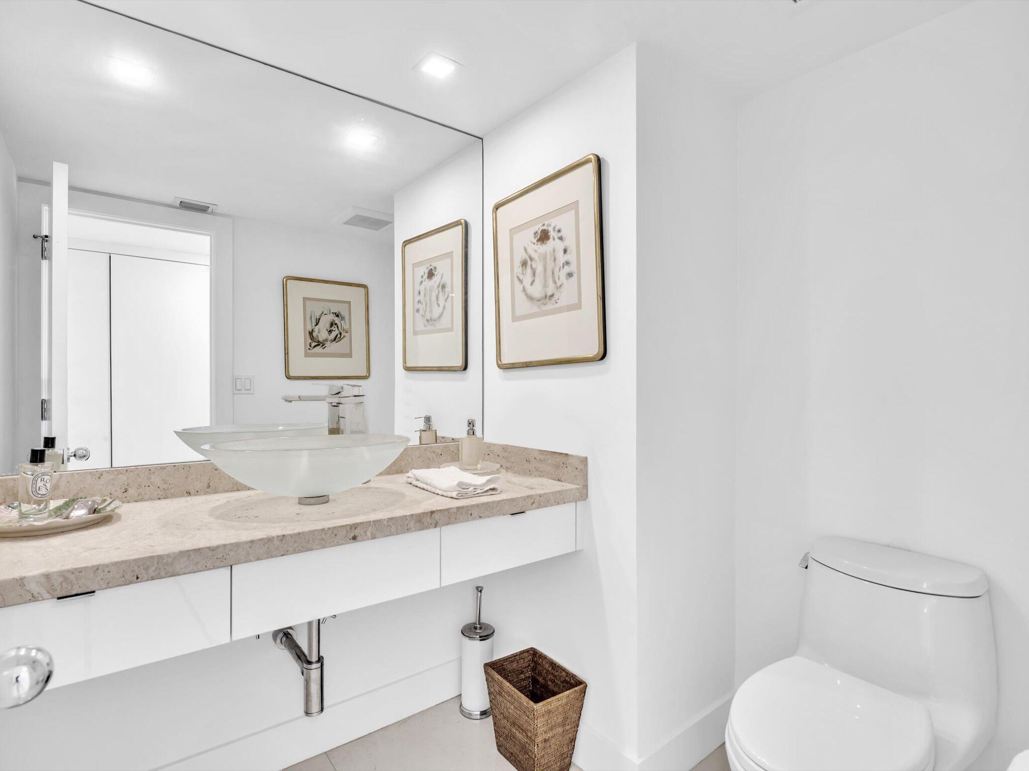 3300 South Ocean Boulevard, Unit 108S Palm Beach, FL 33480 - Photo 23 of 66 a bathroom with a granite countertop toilet sink and mirror