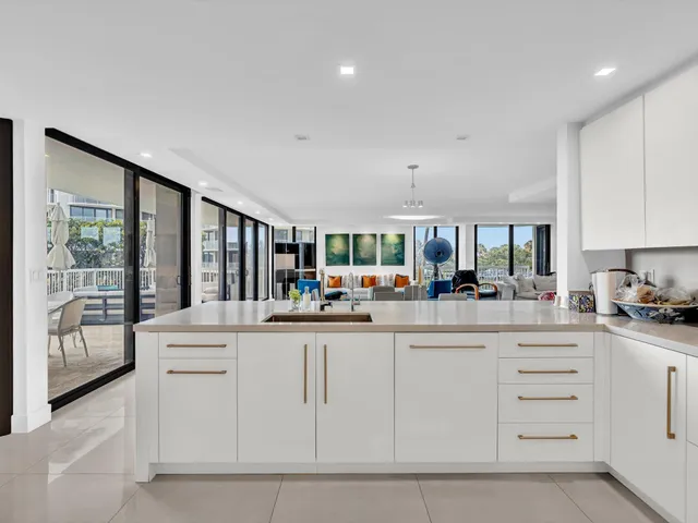 a kitchen with stainless steel appliances kitchen island granite countertop a refrigerator and cabinets