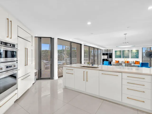a kitchen with white cabinets appliances and sink
