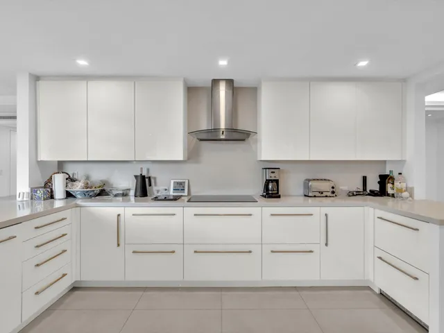 a kitchen with granite countertop white cabinets and white appliances
