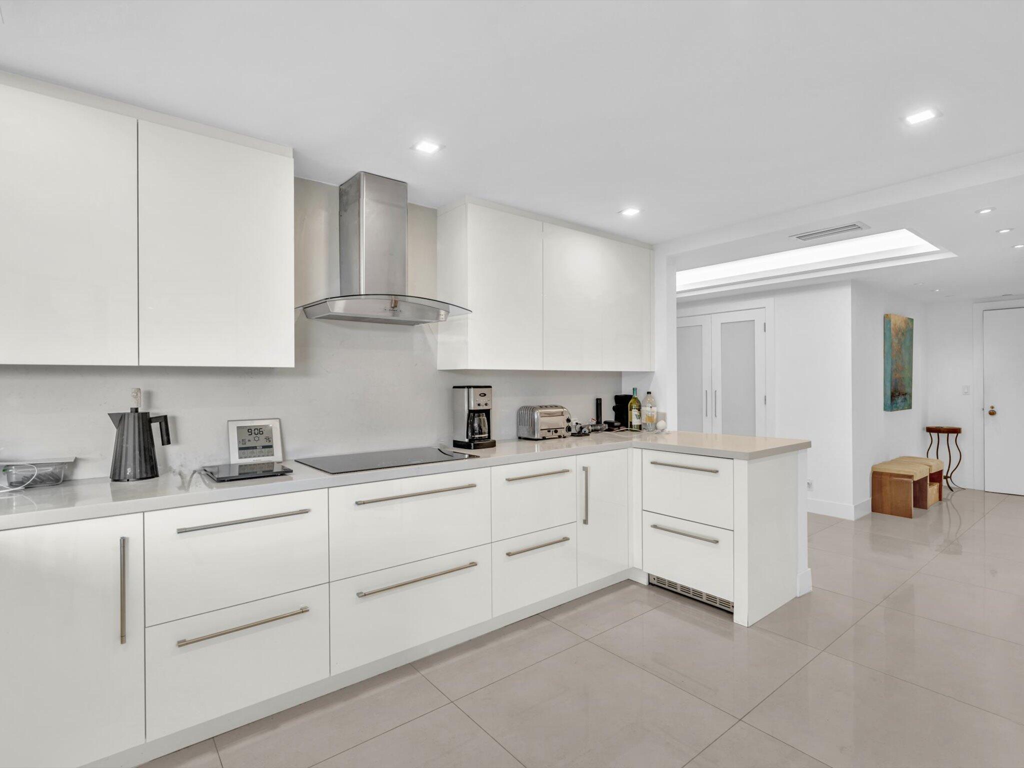 3300 South Ocean Boulevard, Unit 108S Palm Beach, FL 33480 - Photo 7 of 66 a kitchen with granite countertop white cabinets and white appliances