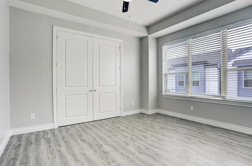 8907 Spring Knoll Forest Drive Houston, TX 77080 - Photo 14 of 21 a view of empty room with wooden floor and fan