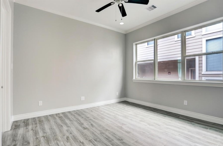 8907 Spring Knoll Forest Drive Houston, TX 77080 - Photo 16 of 21 an empty room with a window and a ceiling fan