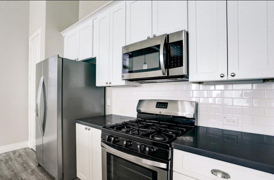 8907 Spring Knoll Forest Drive Houston, TX 77080 - Photo 9 of 21 a kitchen with stainless steel appliances a microwave a stove and cabinets