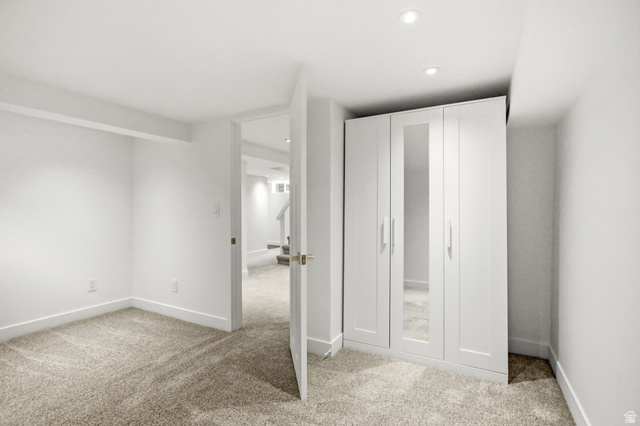 1187 East Ridgedale Circle Millcreek, UT 84106 - Photo 23 of 49 Carpeted room with white walls, recessed lighting, and a built-in white wardrobe featuring mirrored doors and brushed nickel hardware