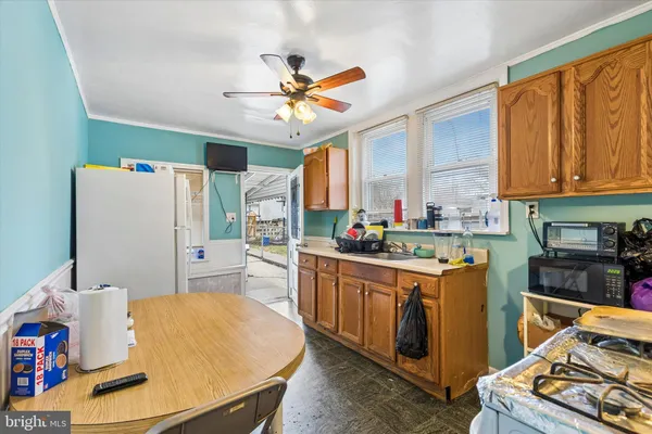 a kitchen with stainless steel appliances a stove a refrigerator a sink a dining table and chairs with wooden floor