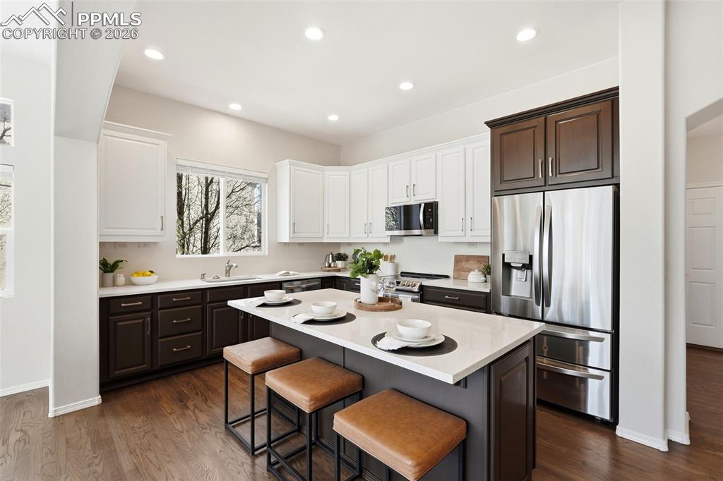 10744 Rhinestone Drive Colorado Springs, CO 80908 - Photo 17 of 50 a kitchen with a sink a stove a refrigerator and wooden floor