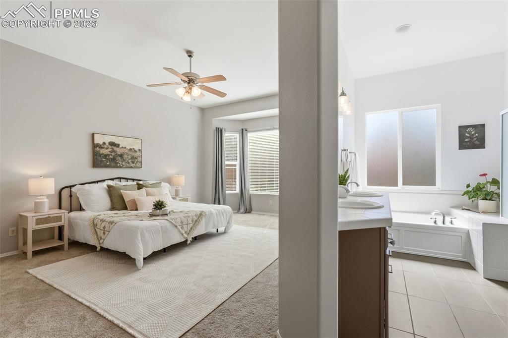 10744 Rhinestone Drive Colorado Springs, CO 80908 - Photo 19 of 50 a en suite bedroom with a large bed and a chandelier