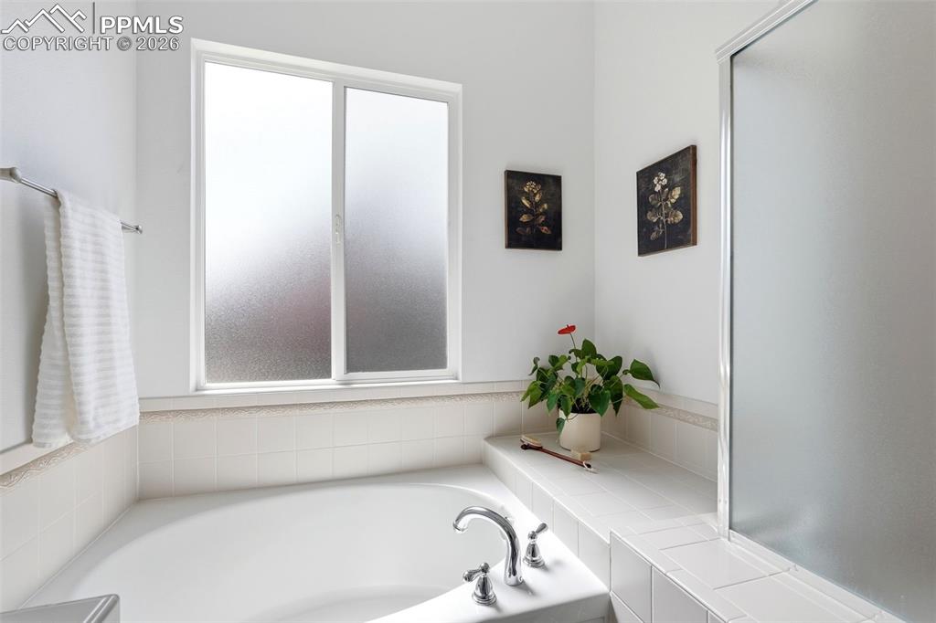 10744 Rhinestone Drive Colorado Springs, CO 80908 - Photo 25 of 50 a bathroom with a sink a mirror and a window